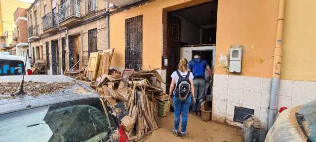 A community helps clear a home on muddy streets in Valencia