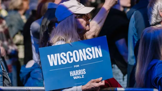 A Harris supporter holds a Wisconsin sign at a rally