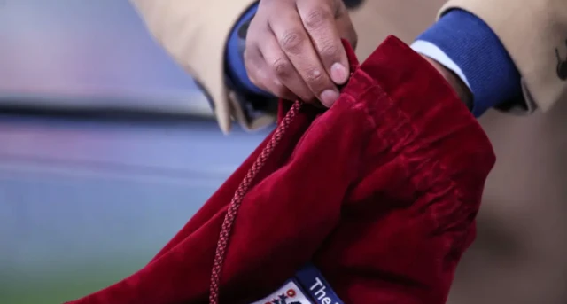 A hand in a bag drawing out balls for the FA Cup