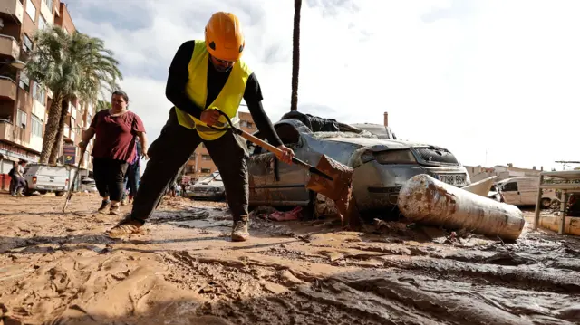 A public worker cleans a street from mud and debris in the flood-hit municipality of Paiporta, in the province of Valencia, Spain, 31 October 2024.