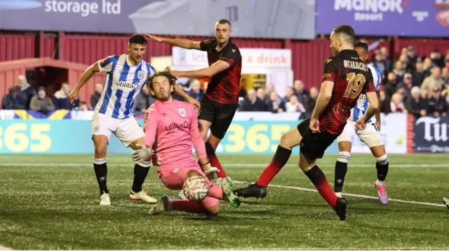 Thomas McGlinchey of Tamworth shoots at goal but is denied by the goalkeeper