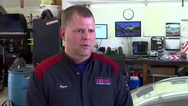 Mechanic Dave Spithaler sitting in a repair shop wearing his overalls