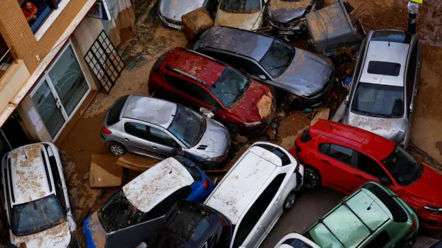 A man looks from his window at piled cars after heavy rains in Sedavi, in Valencia, Spain, October 31, 2024.