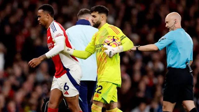 Gabriel is helped from the field by team-mate David Raya after suffering an injury against Liverpool