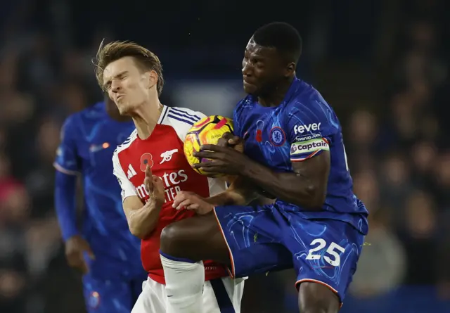 Martin Odegaard is challenged by Moises Caicedo