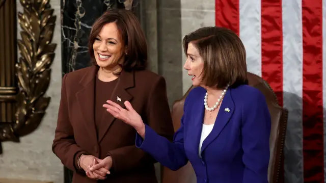 Kamala Harris and Nancy Pelosi pictured standing next to each other at President Joe Biden's first State of the Union address in 2022.