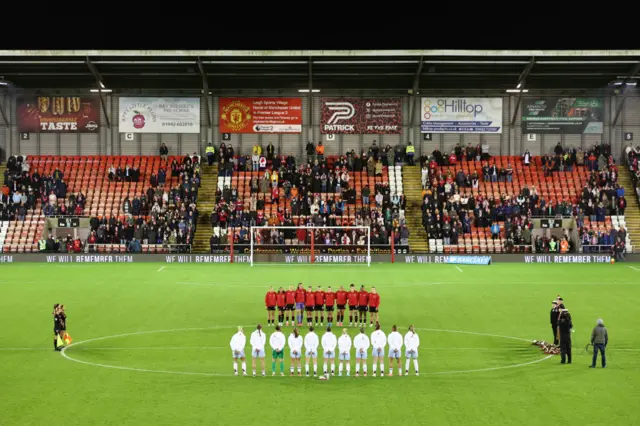 Players gather around the centre circle to mark Remembrance Sunday