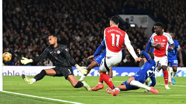 Gabriel Martinelli of Arsenal scores his team's first goal past Robert Sanchez of Chelsea