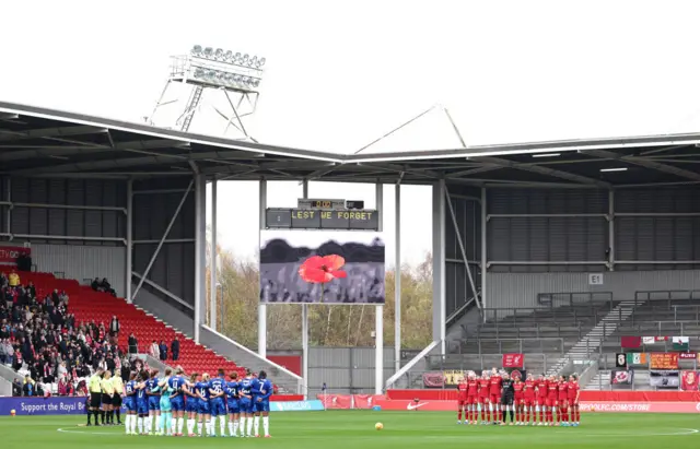 The players line up around the centre circle for a moment of silence for Remembrance day