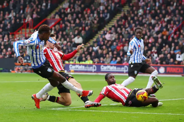 Anthony Musaba of Sheffield Wednesday has a shot blocked by Femi Seriki of Sheffield United