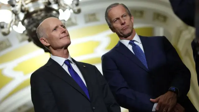 Rick Scott (left) and John Thune (right) stand next to each other at a Senate Republican gathering