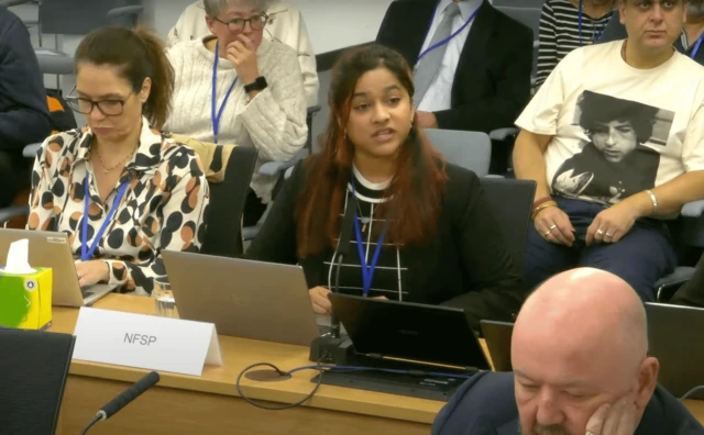 A woman sitting at a table with a laptop