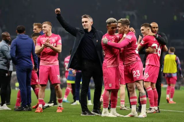 Kieran McKenna celebrates as Omari Hutchinson and Sammie Szmodics of Ipswich Town embrace.