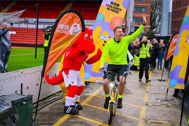 Paddy waves to supporters as he cycles onwards