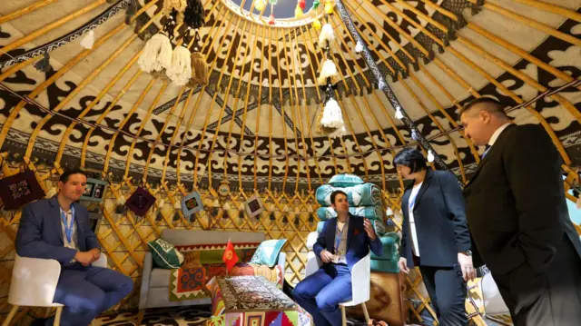 Attendees inside a yurt at the Kyrgyzstan pavilion at the COP29