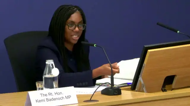 Kemi Badenoch sat at the witness desk at the inquiry with a microphone in front of her