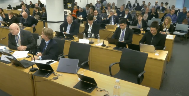 A room with people with suits sitting
