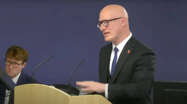 Julian Blake standing at a microphone