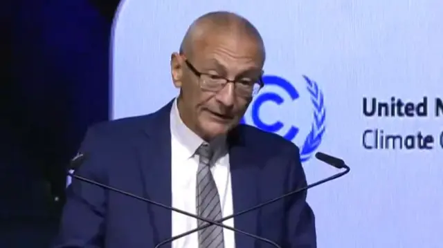 John Podesta talking into two microphones