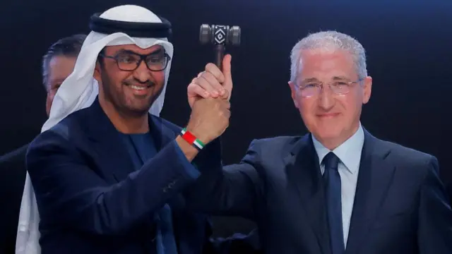 Dr al-Jaber and Babayev both holding a gavel