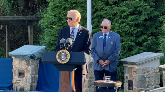 Biden speaks behind a podium