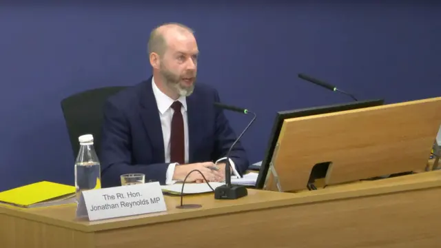 Jonathan Reynolds sitting at a table with a microphone