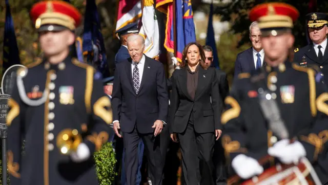 U.S. President Joe Biden and Vice President Kamala Harris walks to attend a wreath laying ceremony at the Tomb of the Unknown Soldier in Arlington National Cemetery on Veterans Day in Arlington, Virginia, U.S., November 11, 2024