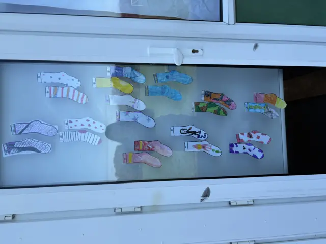 A picture of socks that have been coloured in and decorated different colours and patterns