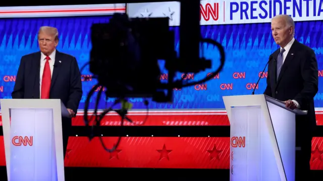 Donald Trump and Joe Biden stand in front of a blue and red screen in a CNN studio.