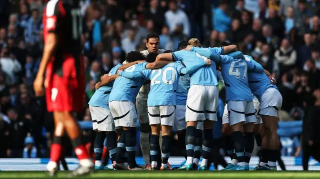 Players of Manchester City enter a huddle