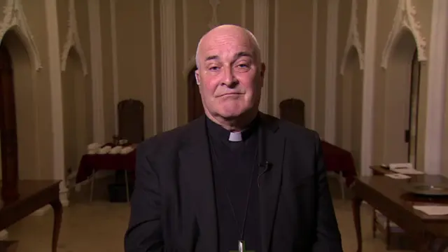 Headshot of Stephen Cottrell standing in a church looking at the camera wearing his religious garments