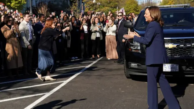 Vice President Kamala Harris responds to administration staff applauding her outside the White House in Washington