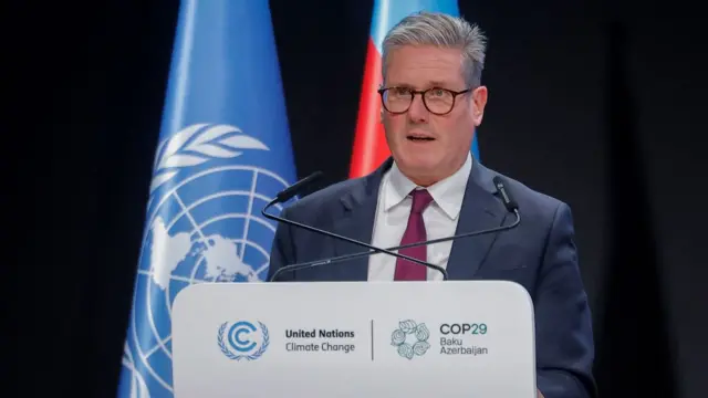 Starmer speaks from the podium at COP, with the UN flag in the background