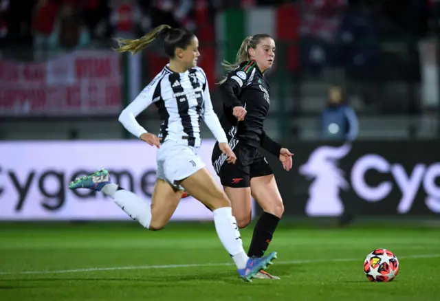 Alessia Russo runs with the ball whilst under pressure from Viola Calligaris