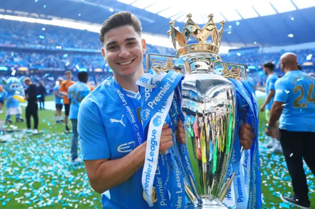 Julian Alvarez of Manchester City holds the Premier League trophy