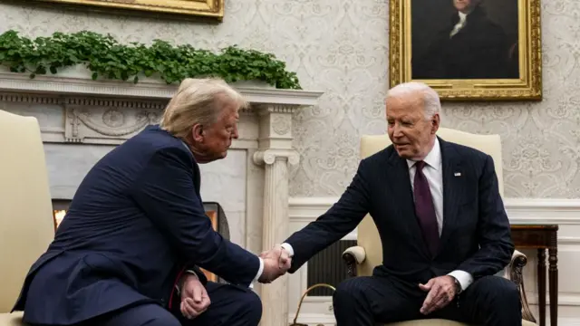 Donald Trump and Joe Biden shake hands at the Oval Office.