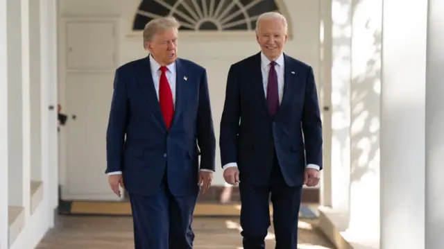 Two men in blue suits walk