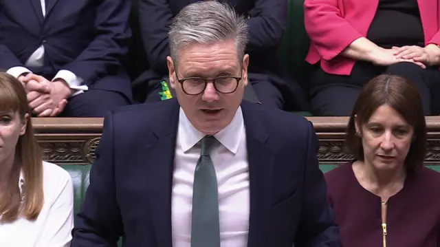 Keir Starmer at dispatch box in suit during PMQs, Angela Rayner sat to his right