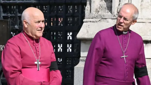 Stephen Cottrell walking with Justin Welby. Both wear religious garments with large crosses round their necks