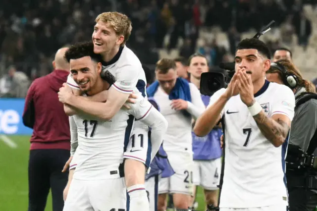 Jones gives Gordon a piggyback as they and Gibbs-White clap the away fans