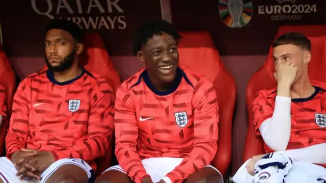 Kobbie Mainoo sits on the bench with Cole Palmer and Joe Gomez