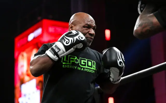 Mike Tyson holds his boxing gloves up to his chest