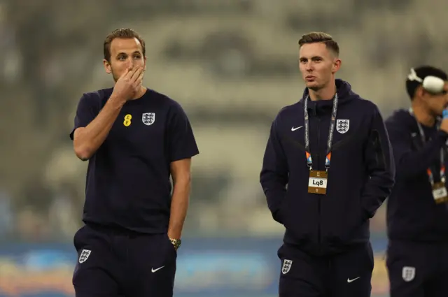 Harry Kane walks around the pitch in Athens with teammates