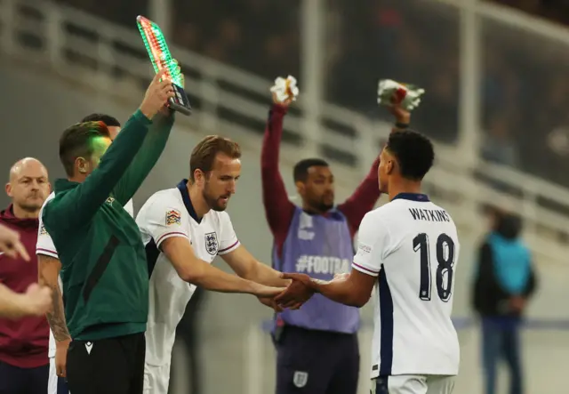 Kane low fives Watkins as he takes his place on the field