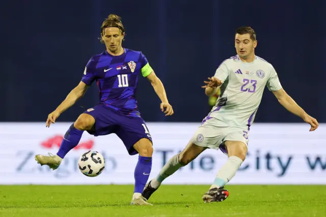 Luka Modric of Croatia is challenged by Kenny McLean of Scotland