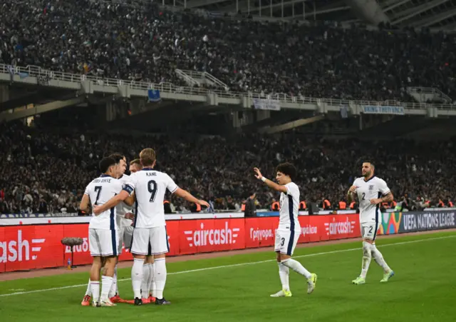 England players celebrate the third goal in Greece at the corner flag