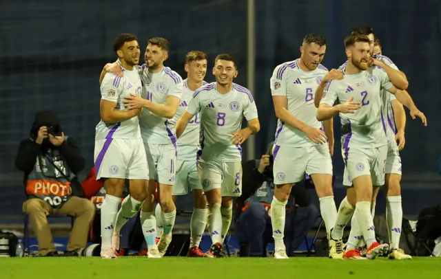 Che Adams of Scotland celebrates scoring a goal with teammates