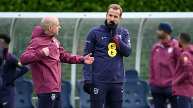 Lee Carsley, Interim Head Coach of England, talks to Harry Kane of England during a training session.