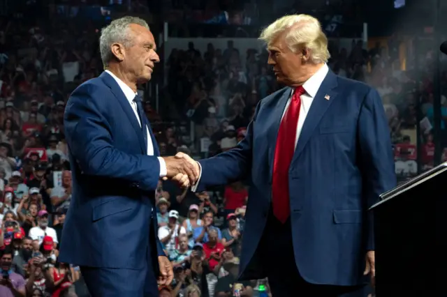 Former Republican presidential candidate Robert F. Kennedy Jr. and Republican presidential nominee, former U.S. President Donald Trump shake hands during a campaign rally at Desert Diamond Arena on August 23, 2024 in Glendale, Arizona.