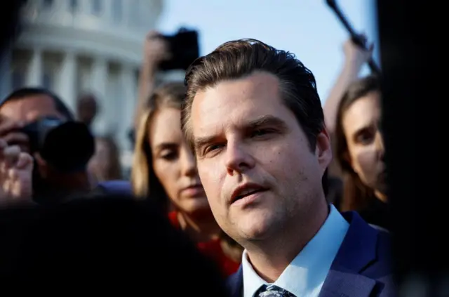 Gaetz, flanked by reporters